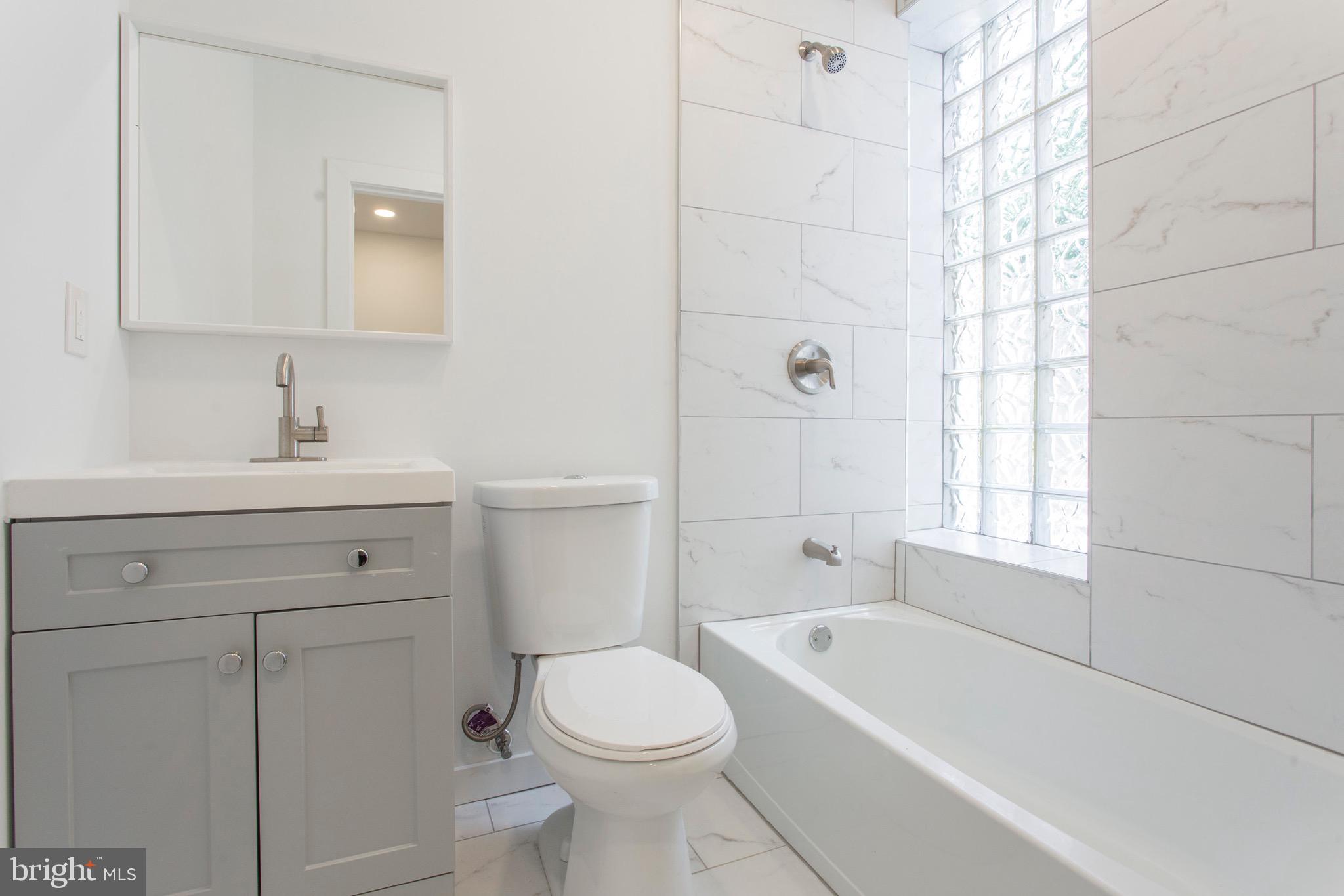 2131 North 8th Street, Unit 2 Philadelphia, PA 19122 - Photo 10 of 19 a bathroom with a sink a toilet and shower