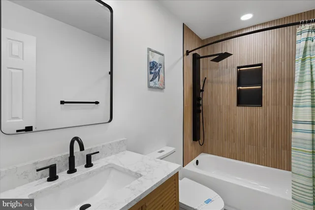 a bathroom with a granite countertop sink toilet and shower