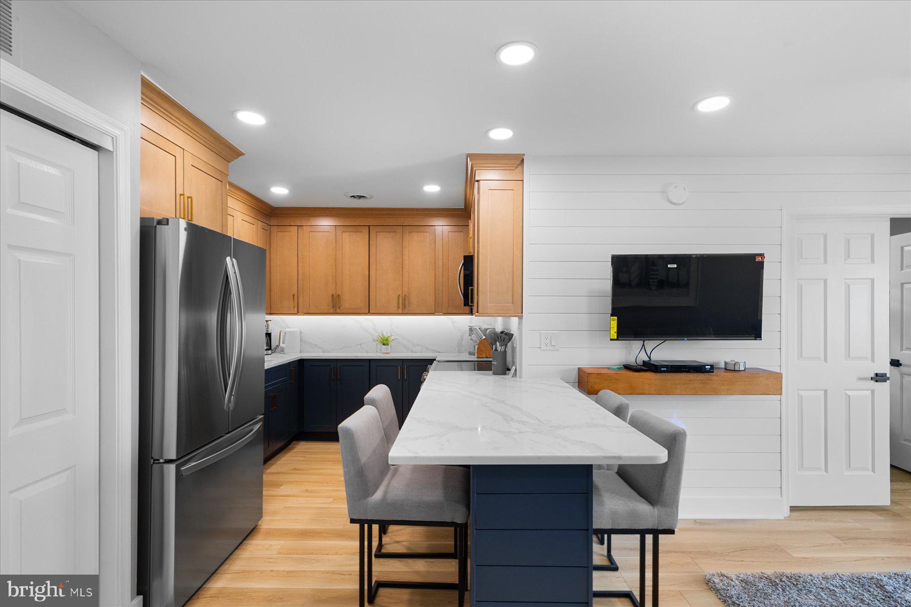 14409 Lighthouse Avenue, Unit 2 Ocean City, MD 21842 - Photo 5 of 39 a kitchen with stainless steel appliances a refrigerator and a table