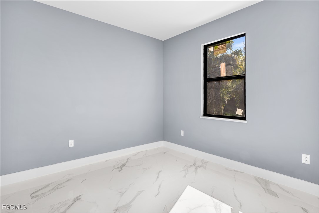 714 Hamilton Avenue Lehigh Acres, FL 33972 - Photo 11 of 30 a view of an empty room with window and wooden floor