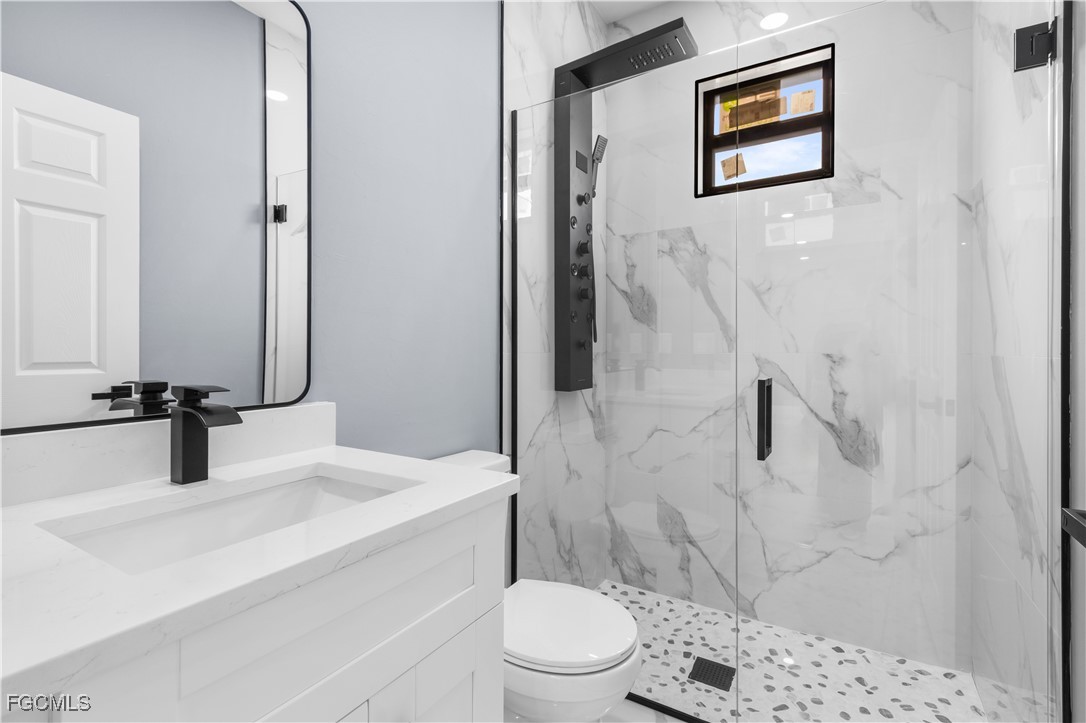 714 Hamilton Avenue Lehigh Acres, FL 33972 - Photo 15 of 30 a bathroom with a sink a toilet and shower