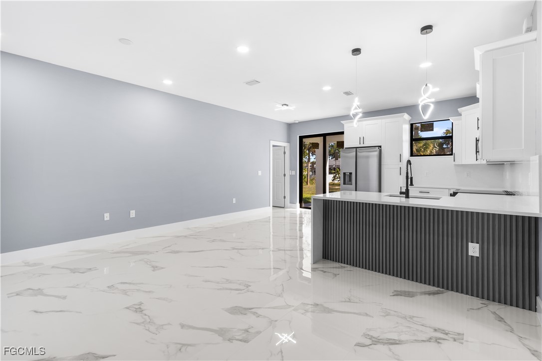 714 Hamilton Avenue Lehigh Acres, FL 33972 - Photo 16 of 30 a kitchen with stainless steel appliances kitchen island sink refrigerator and cabinets