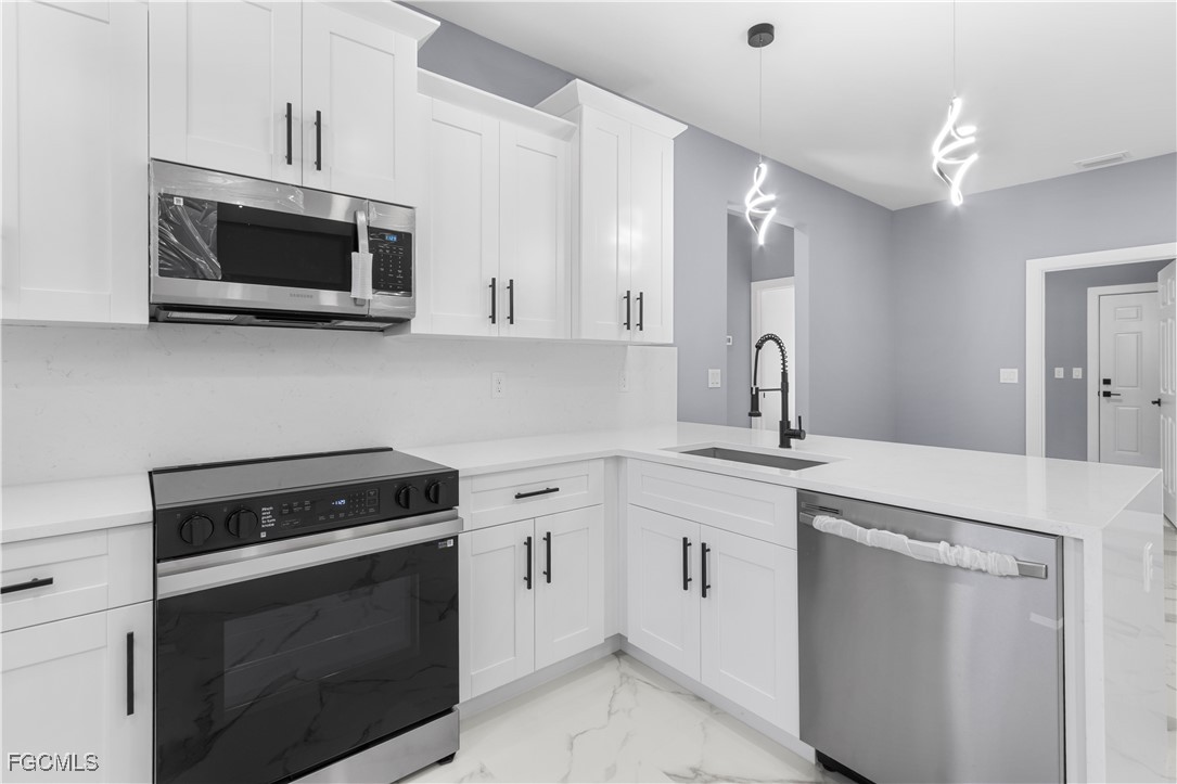 714 Hamilton Avenue Lehigh Acres, FL 33972 - Photo 20 of 30 a kitchen with white cabinets and stainless steel appliances