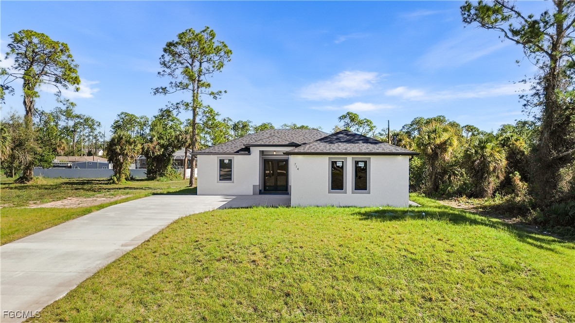 714 Hamilton Avenue Lehigh Acres, FL 33972 - Photo 3 of 30 a view of a house with a yard