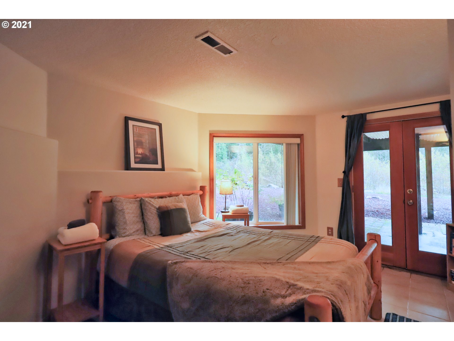 21982 East Lolo Pass Road Rhododendron, OR 97049 - Photo 27 of 32 a bedroom with a large bed and a large window