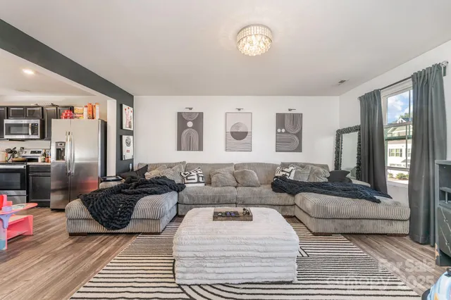 a living room with furniture kitchen view and a window
