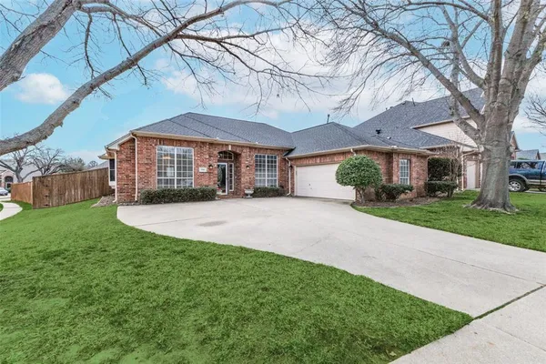 a front view of a house with a yard and potted plants