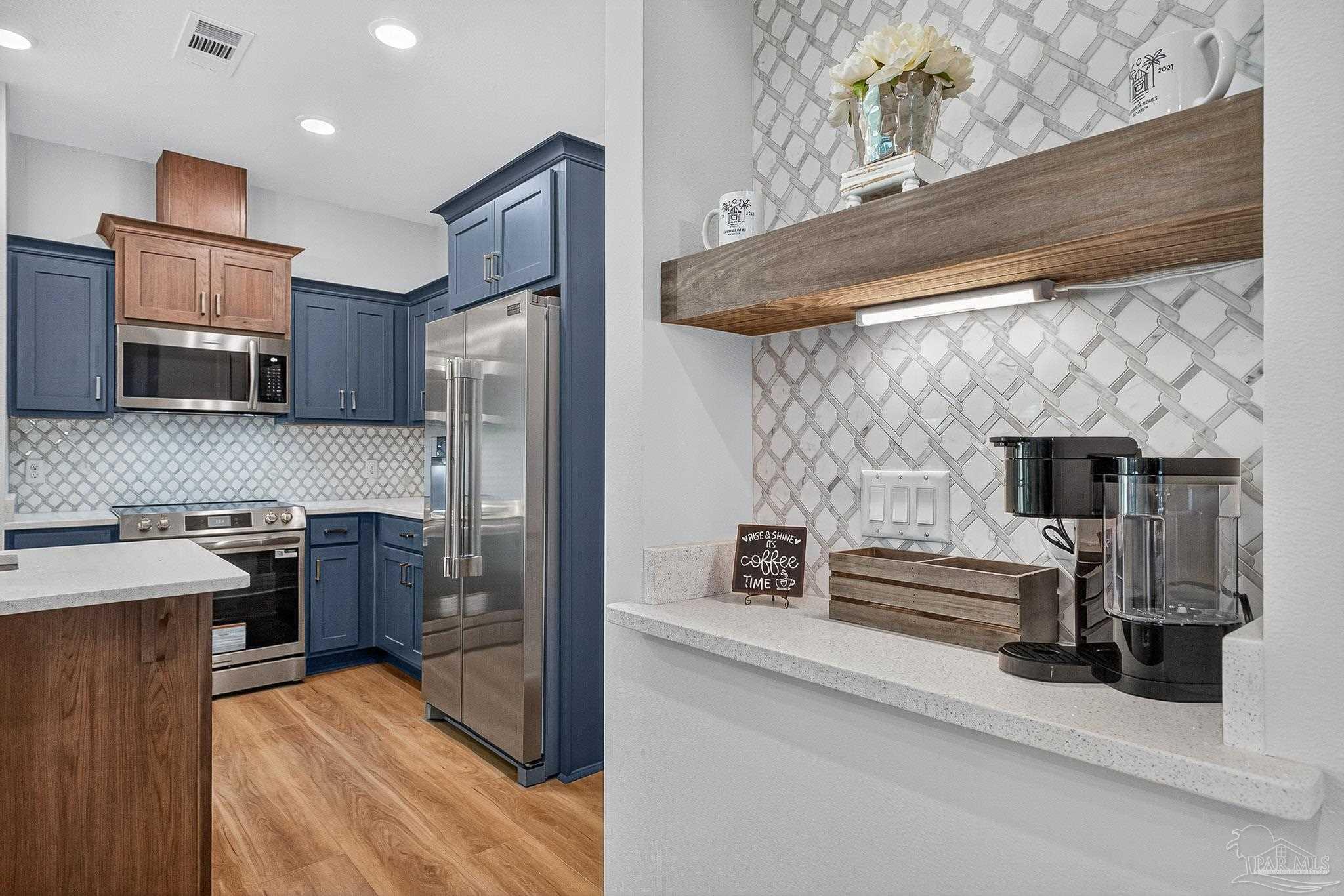 a kitchen with stainless steel appliances a refrigerator and a stove top oven