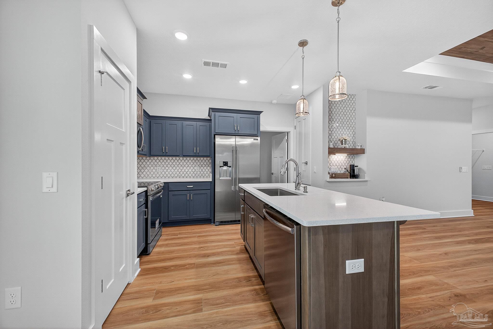 6115 Carroll Road Milton, FL 32583 - Photo 20 of 57 a kitchen with kitchen island a sink stainless steel appliances and cabinets