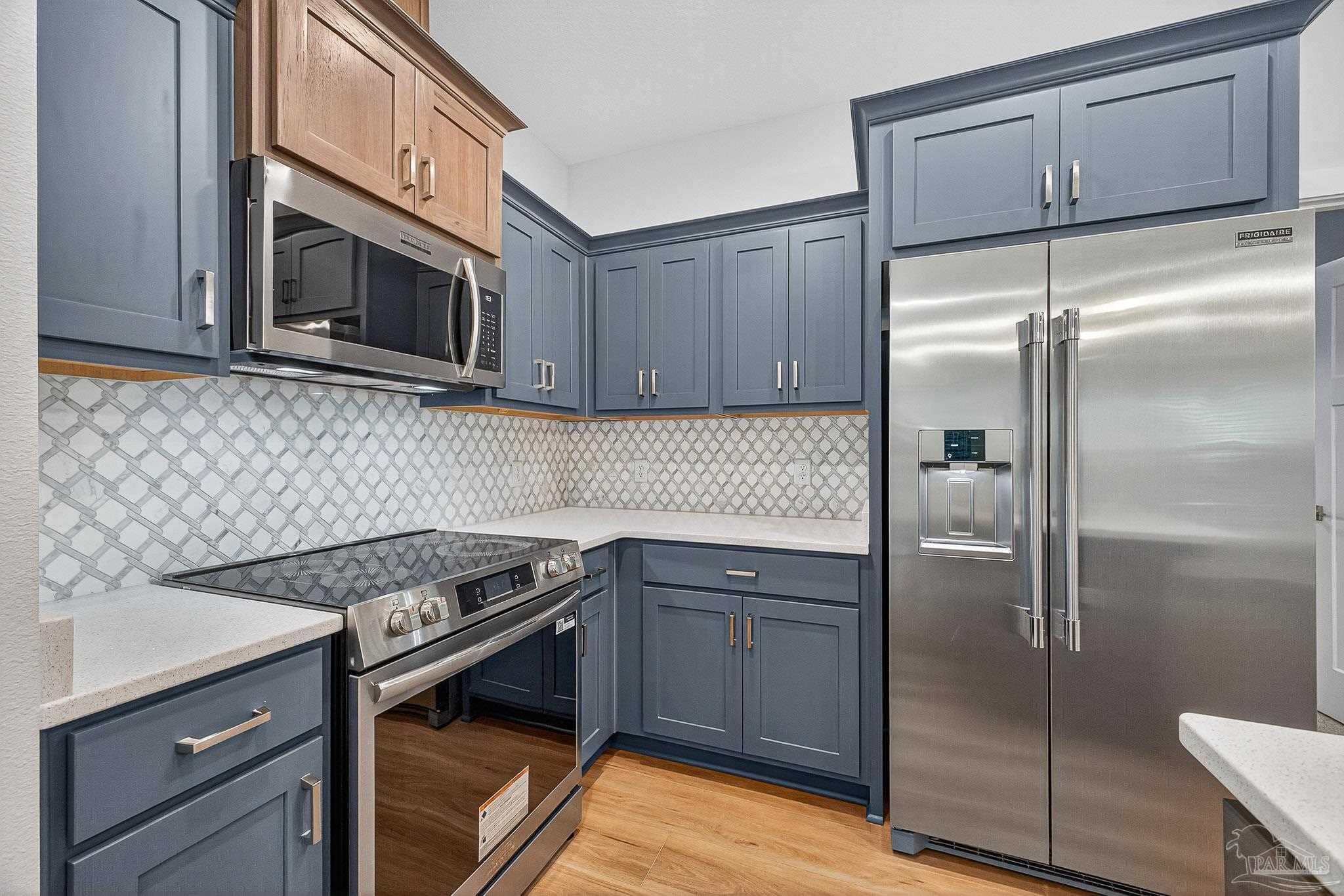 6115 Carroll Road Milton, FL 32583 - Photo 23 of 57 a kitchen with stainless steel appliances granite countertop a stove a refrigerator and a microwave