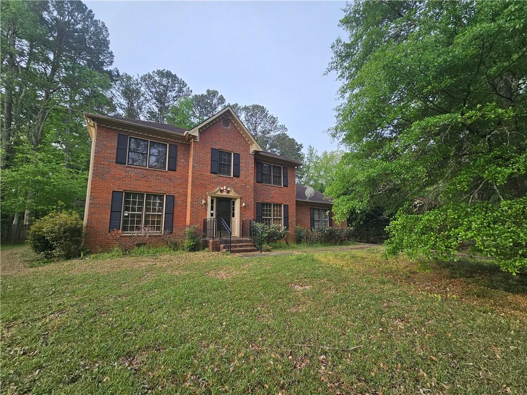 1935 Coventry Way Jonesboro, GA 30236 - Photo 1 of 33 a view of a yard in front of a brick house with large windows