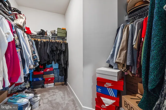 a view of walk in closet with clothes and shoes