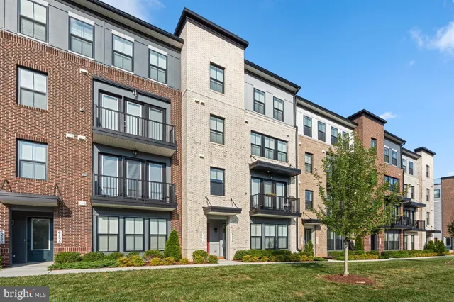 a front view of a residential apartment building with a yard