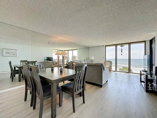 a dining room with furniture window and wooden floor