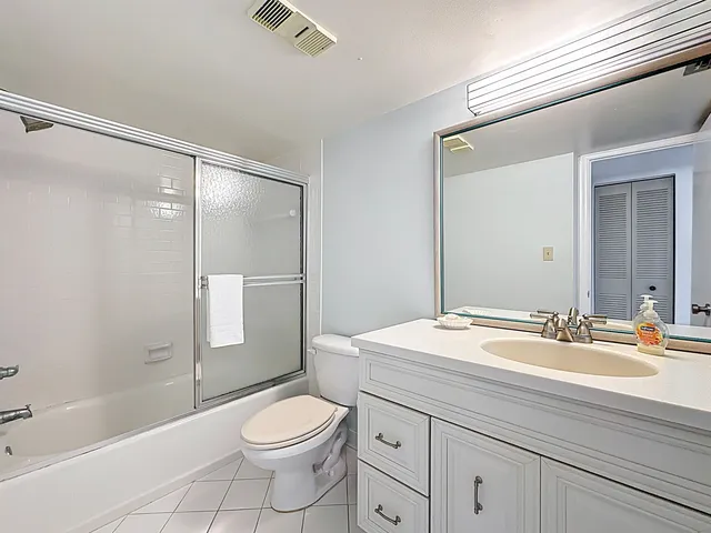 a bathroom with a sink a toilet a mirror and shower