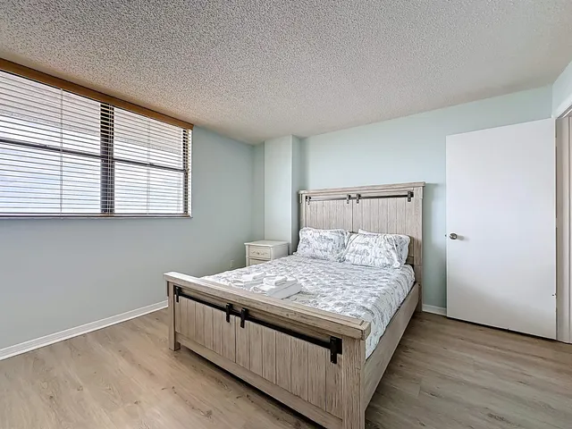 a bed sitting in a bedroom next to a window
