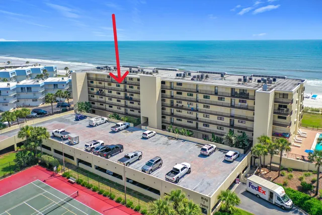 a view of a tennis court with a table and chairs