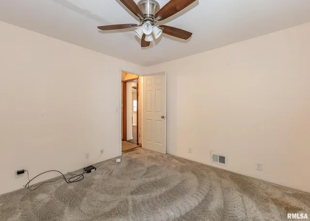 a view of a room with a ceiling fan and a window