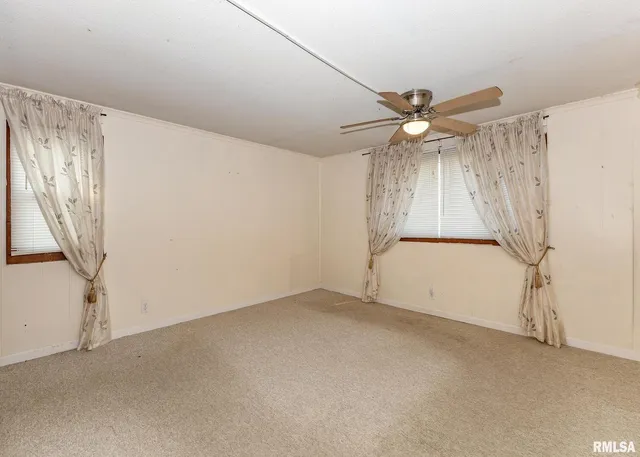 an empty room with a ceiling fan and a window