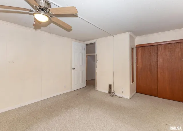 an empty room with closet and chandelier fan