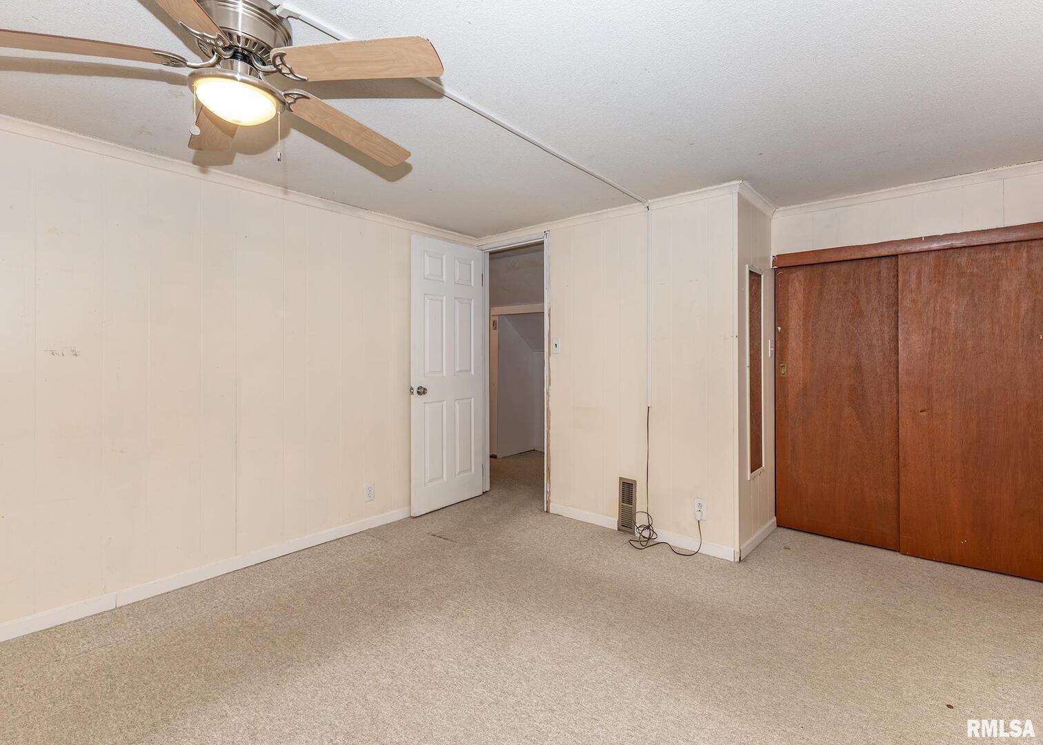 3015 North 3rd Street Clinton, IA 52732 - Photo 17 of 28 an empty room with closet and chandelier fan