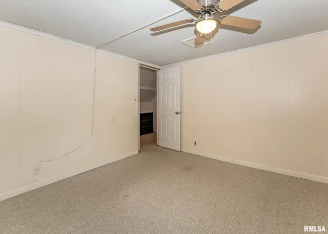 an empty room with a ceiling fan and a window