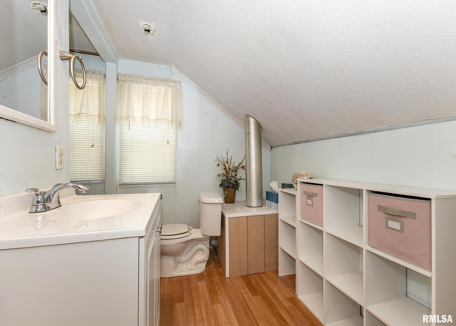 3015 North 3rd Street Clinton, IA 52732 - Photo 20 of 28 a bathroom with a sink mirror vanity and toilet