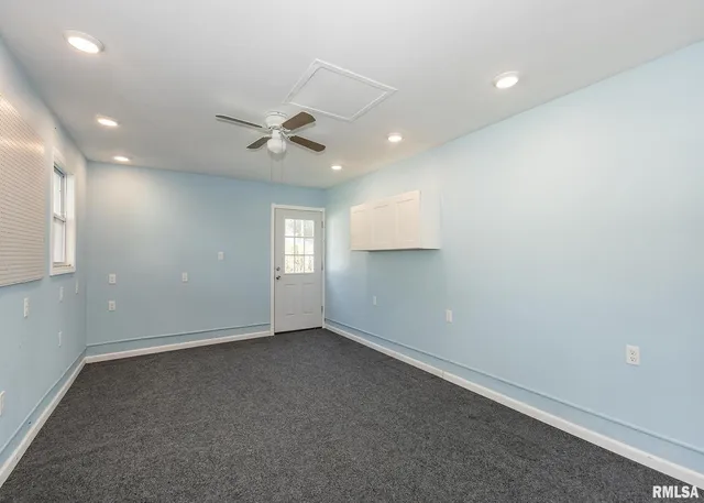 an empty room with window and ceiling fan