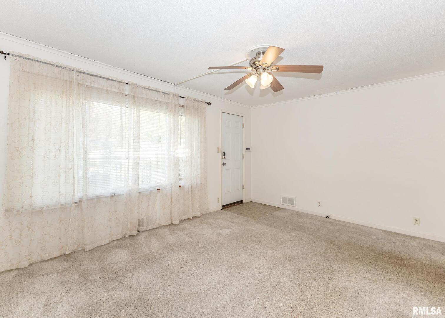 3015 North 3rd Street Clinton, IA 52732 - Photo 5 of 28 an empty room with windows and fan