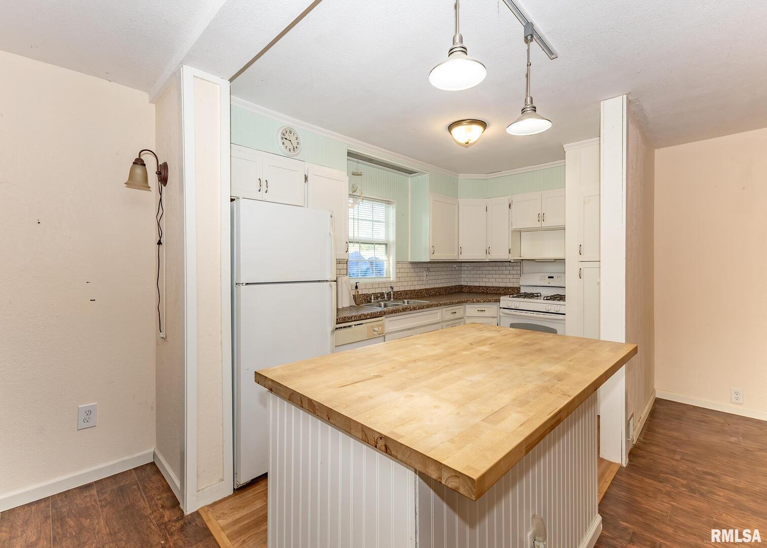 3015 North 3rd Street Clinton, IA 52732 - Photo 7 of 28 a kitchen with refrigerator cabinets and wooden floor