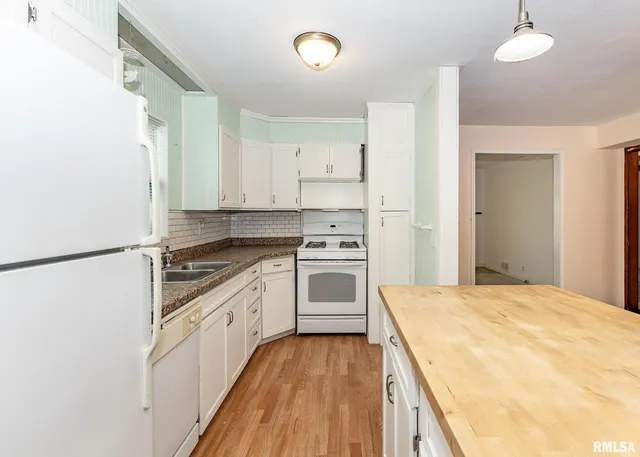 a kitchen with white cabinets and white appliances