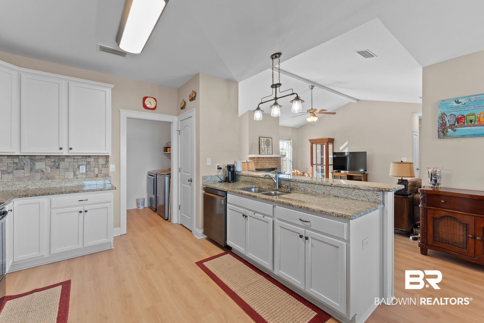 28980 Comstock Road Elberta, AL 36530 - Photo 37 of 38 Kitchen with decorative light fixtures, white cabinetry, open floor plan, light stone counters, and a peninsula