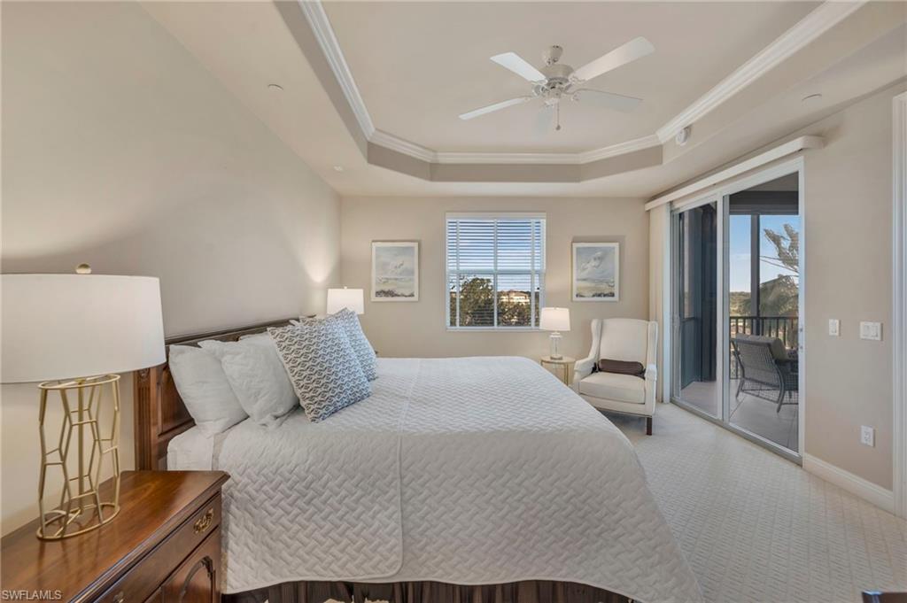 580 El Camino Real, Unit 3402 Naples, FL 34119 - Photo 11 of 35 a bedroom with a large bed and a chandelier
