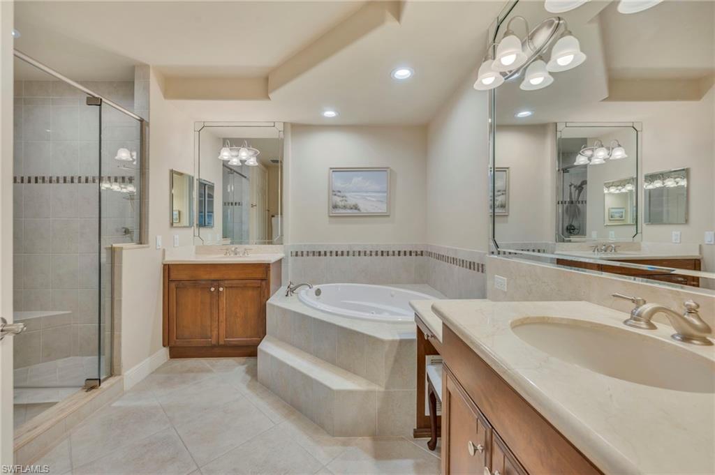 580 El Camino Real, Unit 3402 Naples, FL 34119 - Photo 12 of 35 a bathroom with a tub a sink shower and mirror
