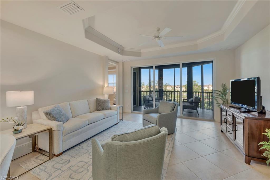 580 El Camino Real, Unit 3402 Naples, FL 34119 - Photo 34 of 35 a living room with furniture a flat screen tv and a floor to ceiling window