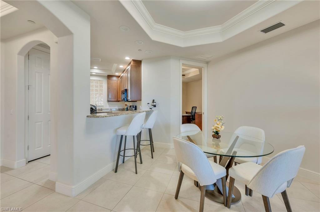 580 El Camino Real, Unit 3402 Naples, FL 34119 - Photo 7 of 35 a view of a dining room with furniture and a chandelier fan