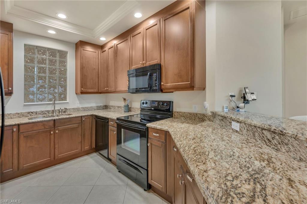580 El Camino Real, Unit 3402 Naples, FL 34119 - Photo 10 of 35 a kitchen with stainless steel appliances granite countertop a sink stove and microwave