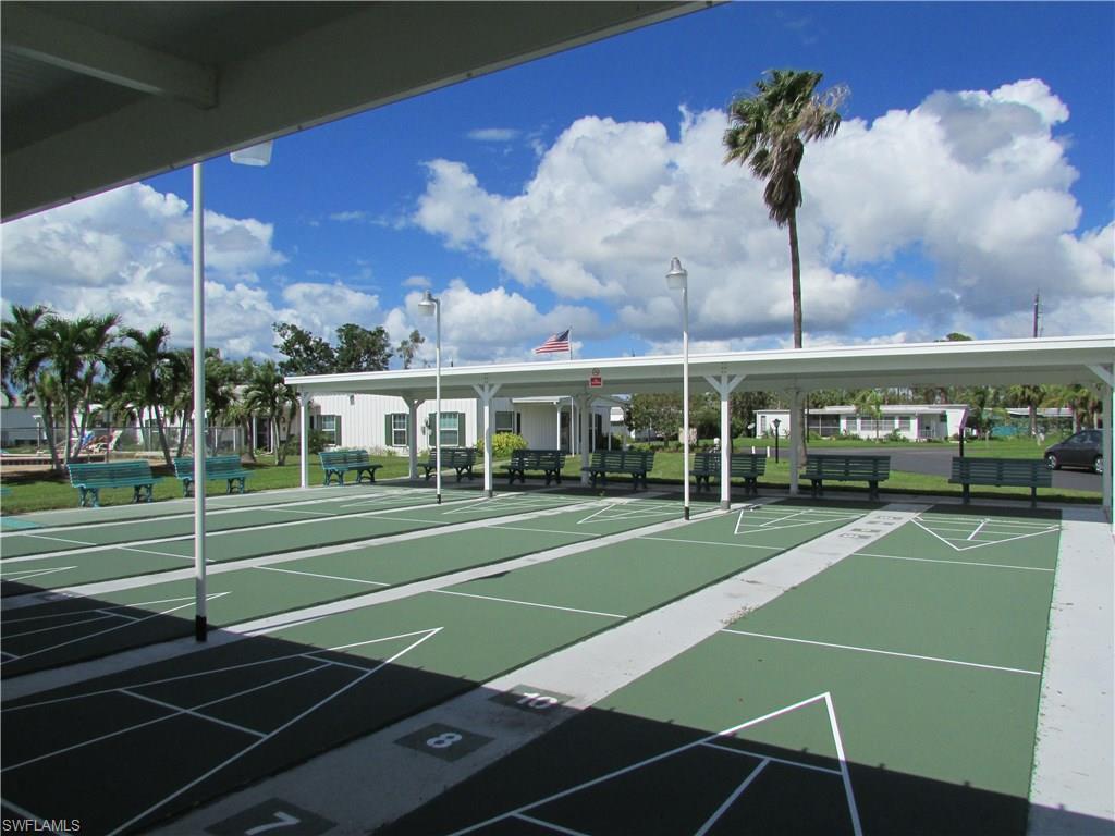113 Enchanting Boulevard, Unit E113 Naples, FL 34112 - Photo 11 of 11 a view of a tennis ground with large trees