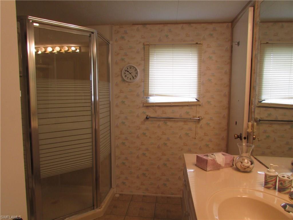 113 Enchanting Boulevard, Unit E113 Naples, FL 34112 - Photo 6 of 11 a bathroom with a sink and a mirror