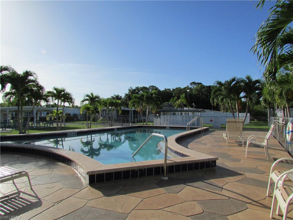 113 Enchanting Boulevard, Unit E113 Naples, FL 34112 - Photo 10 of 11 a view of a swimming pool with a lounge chair