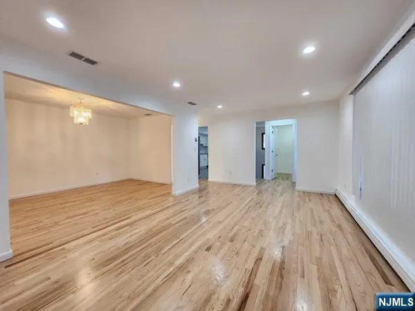 a view of empty room with wooden floor