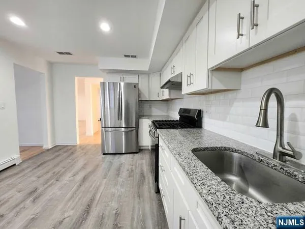 a kitchen with a sink a refrigerator and cabinets