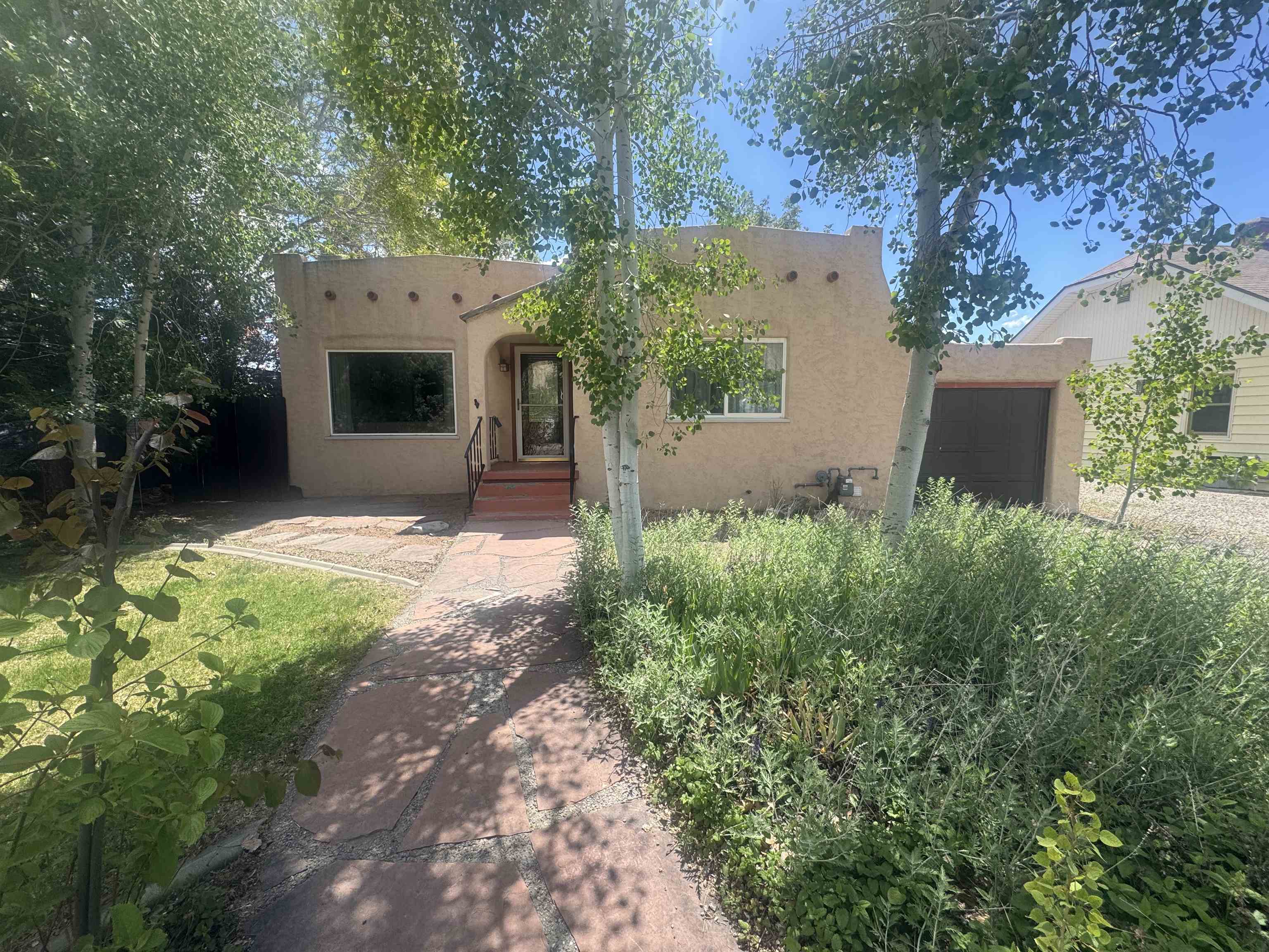 435 West 4th Street Palisade, CO 81526 - Photo 2 of 28 a backyard of a house with a garden and plants