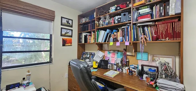 a living room with furniture and a book shelf