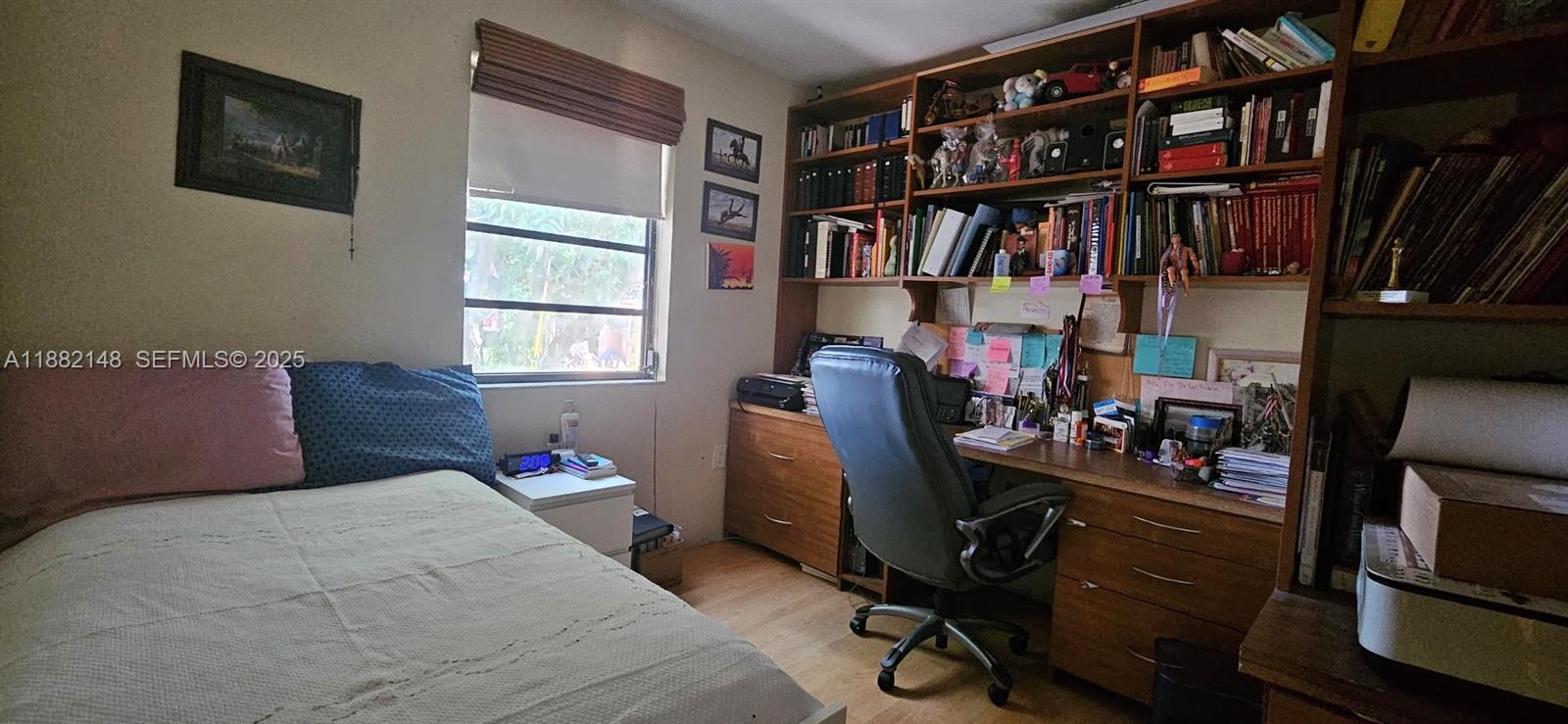 243 Northwest 62nd Court Miami, FL 33126 - Photo 17 of 19 a bedroom with a bed furniture and a book shelf