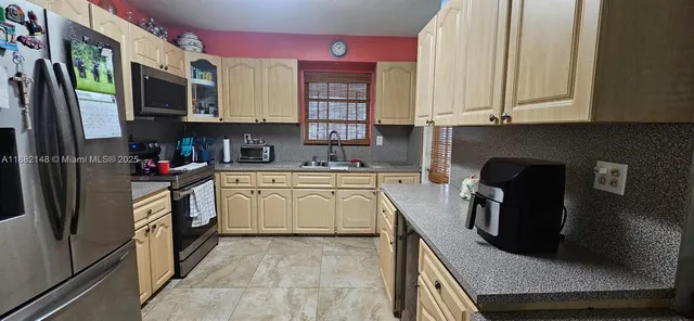 a kitchen with stainless steel appliances granite countertop a refrigerator a stove top oven a sink and dishwasher