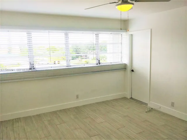 a view of a kitchen with wooden floor and a window