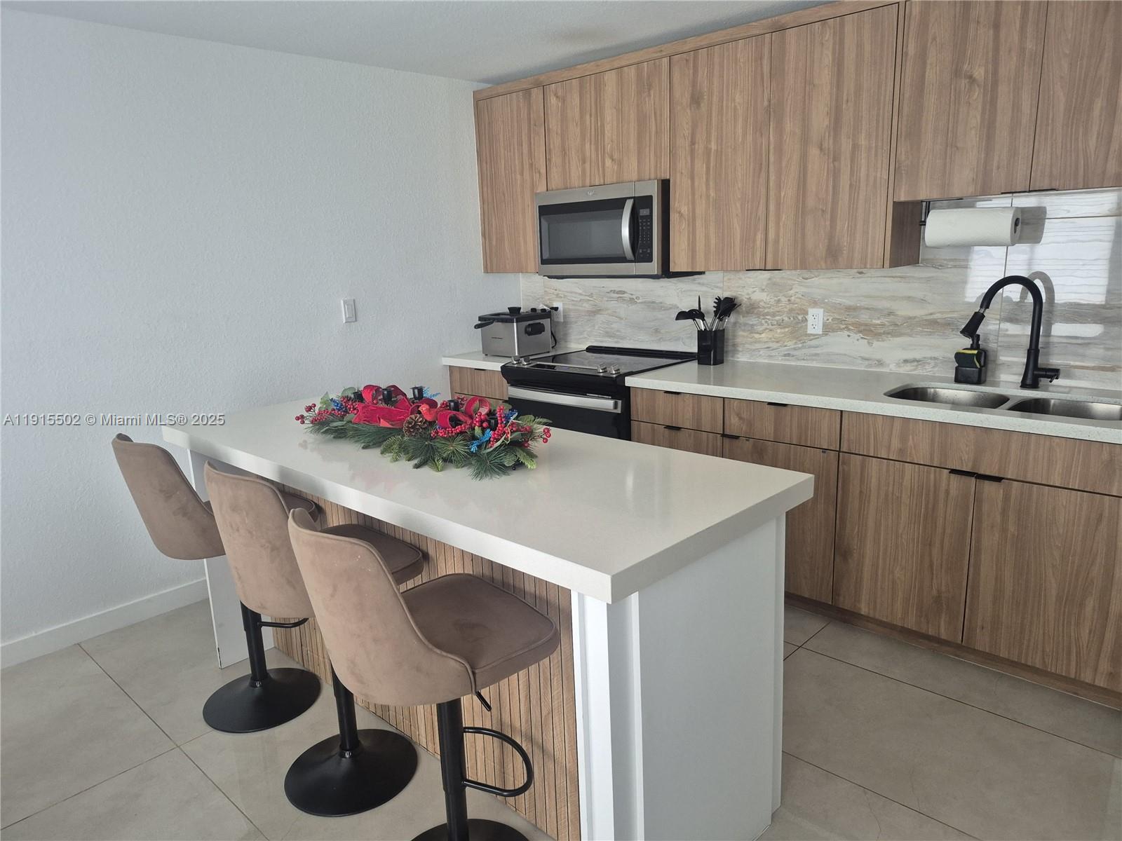 14515 Southwest 261st Street, Unit 14515 Homestead, FL 33032 - Photo 11 of 13 a kitchen with a sink cabinets and appliances
