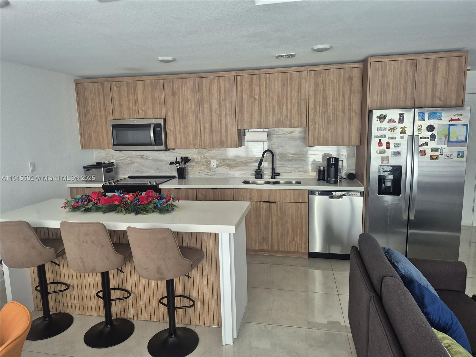 14515 Southwest 261st Street, Unit 14515 Homestead, FL 33032 - Photo 13 of 13 a kitchen with refrigerator cabinets and chairs