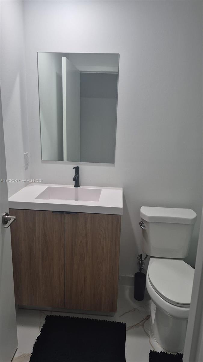 14515 Southwest 261st Street, Unit 14515 Homestead, FL 33032 - Photo 2 of 13 a bathroom with a sink a toilet and mirror